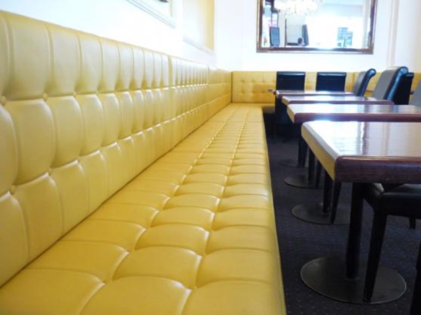 Yellow buttoned vinyl banquette in a café