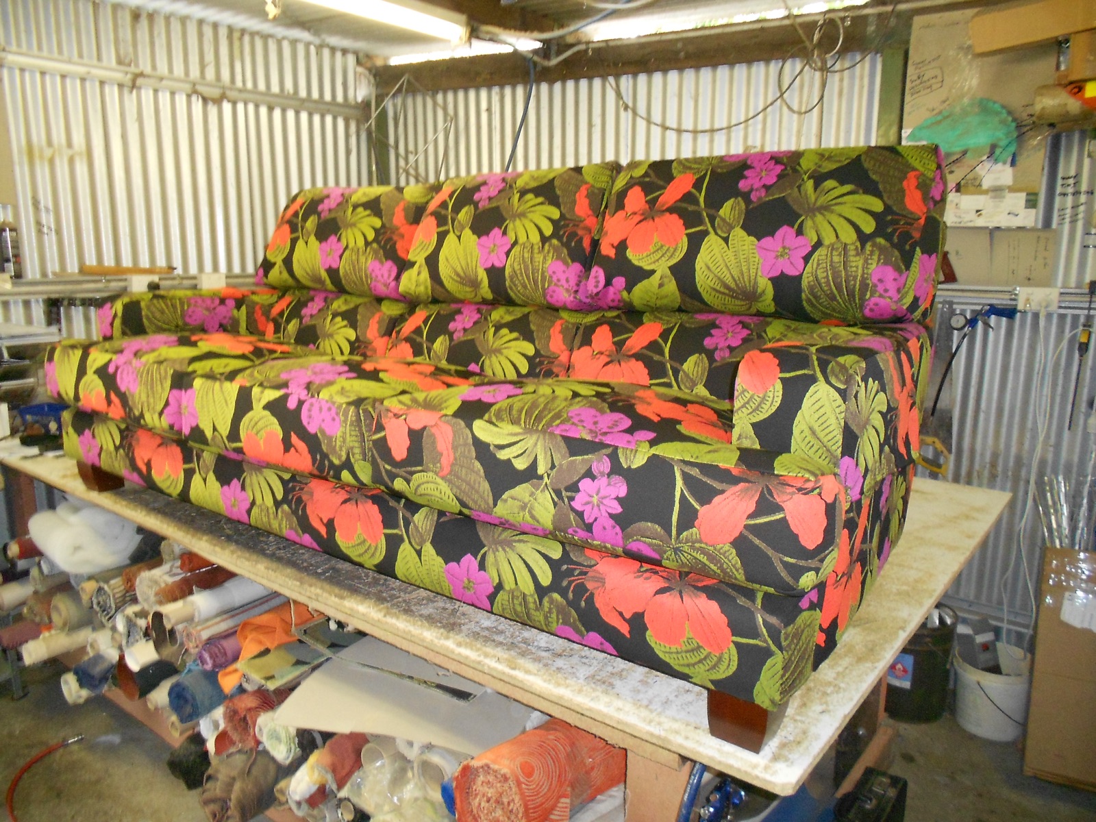 Retro sofa reupholstered in bold floral fabric in the workshop
